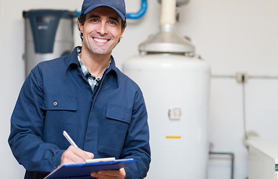 smiling technician repairing gas hot water system